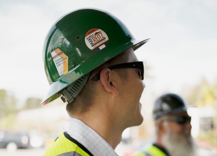 Closeup of a man's hard hat and sunglasses